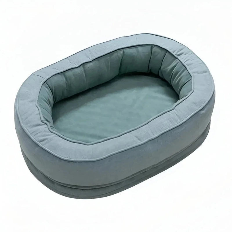 Blue oval dog bed with padded bolster on white background