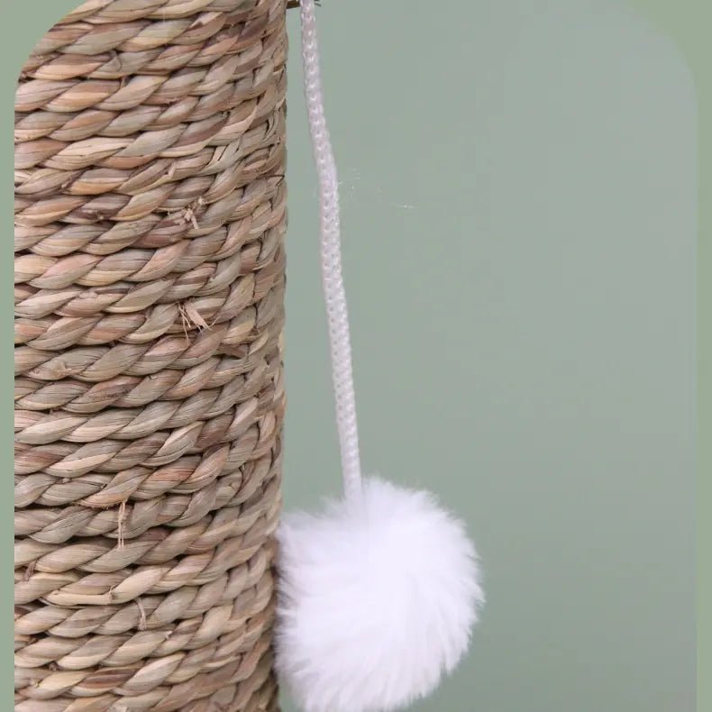 Close-up of a natural woven cactus cat scratcher with a dangling white pom-pom toy, perfect for playful cats.