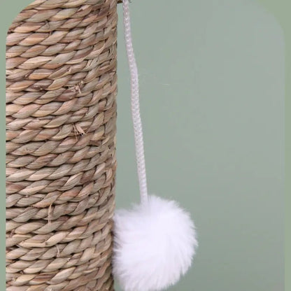 Close-up of a natural woven cactus cat scratcher with a dangling white pom-pom toy, perfect for playful cats.