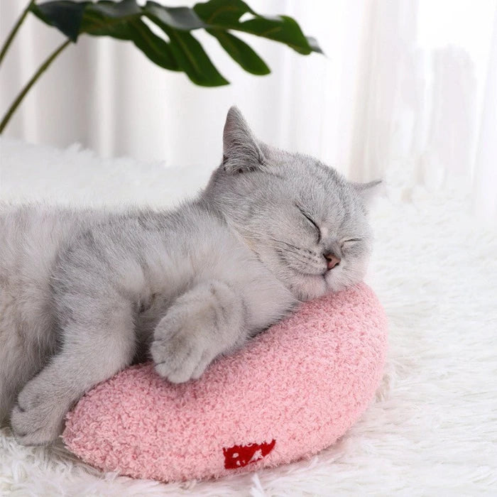 Gray cat sleeping comfortably on a pink calming pet pillow, designed to provide ultimate relaxation and support.