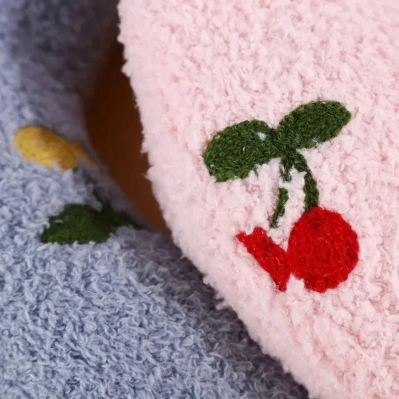 Close-up of soft pink and blue calming pet pillows with cherry and lemon embroidery, providing comfort and style for pets.