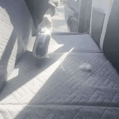 vacuum cleaning pet hair from a car seat cover for dogs