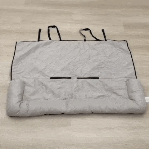 car seat protectors for dogs shown folded with a carry strap on the floor