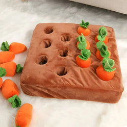 Carrot treat puzzle dog toy with plush carrots and visible treat holes on a mat