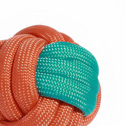 Close-up view of a durable rope ball dog toy in vibrant orange and teal colors.