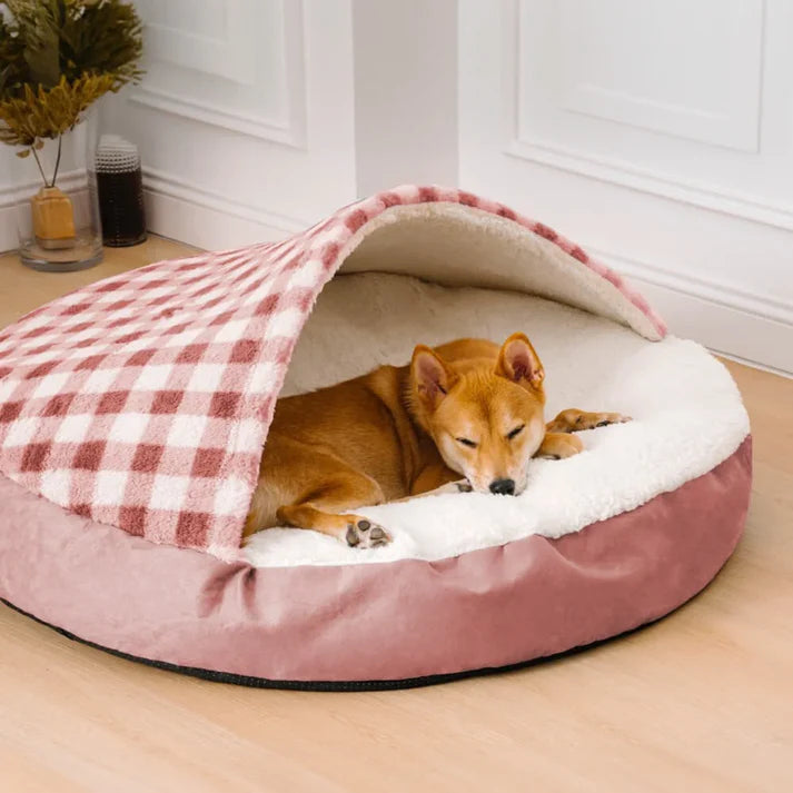 Cozy covered dog bed in soft pink and white, featuring a sleeping dog enjoying comfort and warmth in a stylish design.