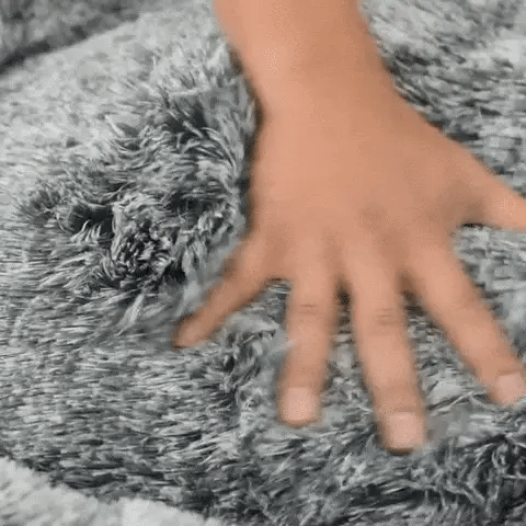 Hands show the soft cover and base so giant dog beds for humans feel supportive