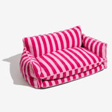 Pink dog sofa bed with striped plush fabric on a white background