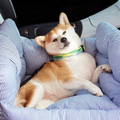 Shiba Inu relaxing in a blue striped dog car seat with seatbelt, offering comfort and safety for road trips and travel.