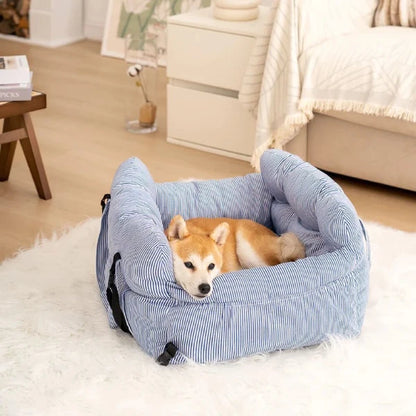 Shiba Inu resting in a cozy striped blue dog car seat with seatbelt, perfect for home or travel comfort.