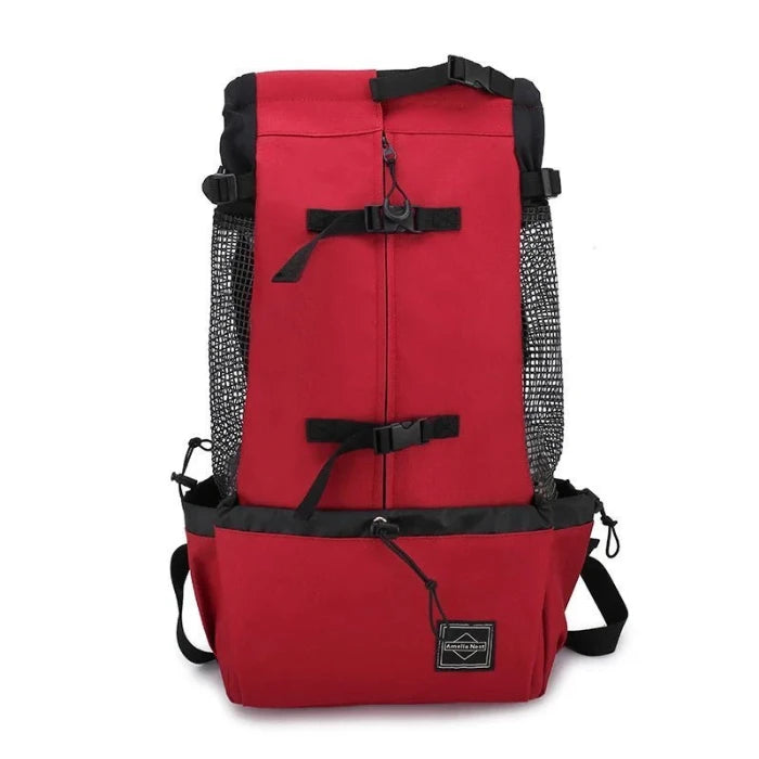 Red pet carrier backpack with adjustable straps and mesh ventilation, perfect for traveling with small pets in comfort.