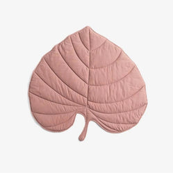 Pink dog floor mat in leaf shape with quilted stitching on a white background
