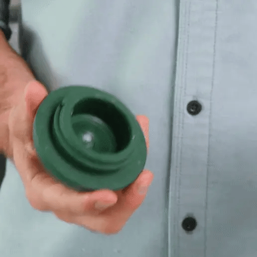 hand placing a frozen food ball into a dog licking toy for anxiety and twisting it closed