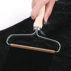 Dog and cat lint scraper removing fur from black fabric
