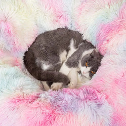 Cat curled up in a cozy fluffy bed featuring pastel pink and blue colors for a warm, comfortable rest.