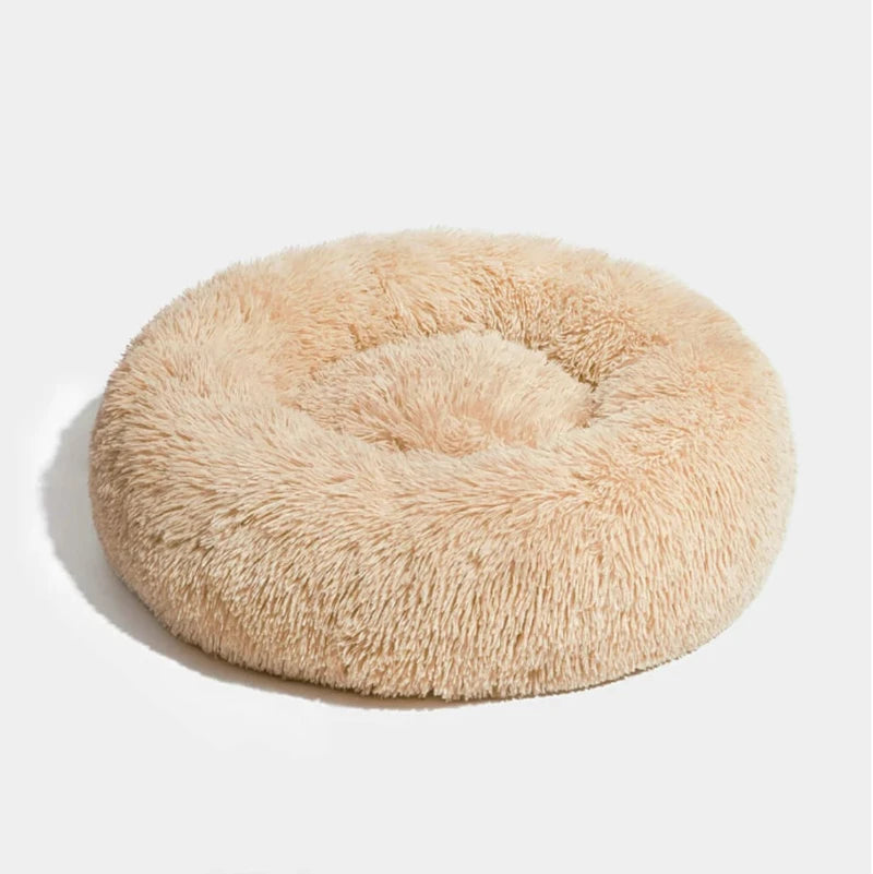 Beige fluffy round dog bed, designed for comfort and coziness, perfect for pets to snuggle and relax in style.