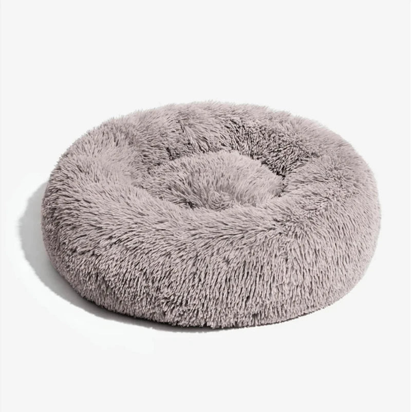 Soft fluffy round dog bed in light brown, perfect for providing comfort and warmth for pets.