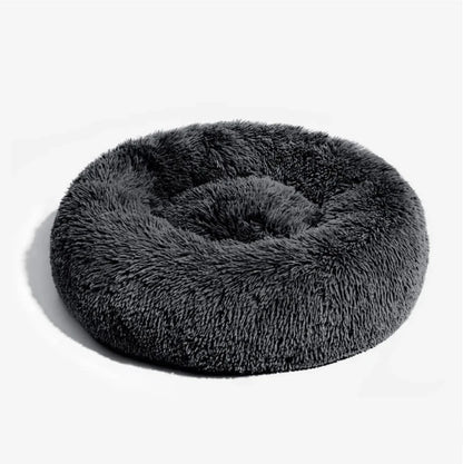 Plush fluffy round dog bed in dark gray, providing cozy comfort for pets to snuggle and relax.