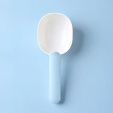 Blue and white pet food scoop shown on a blue background