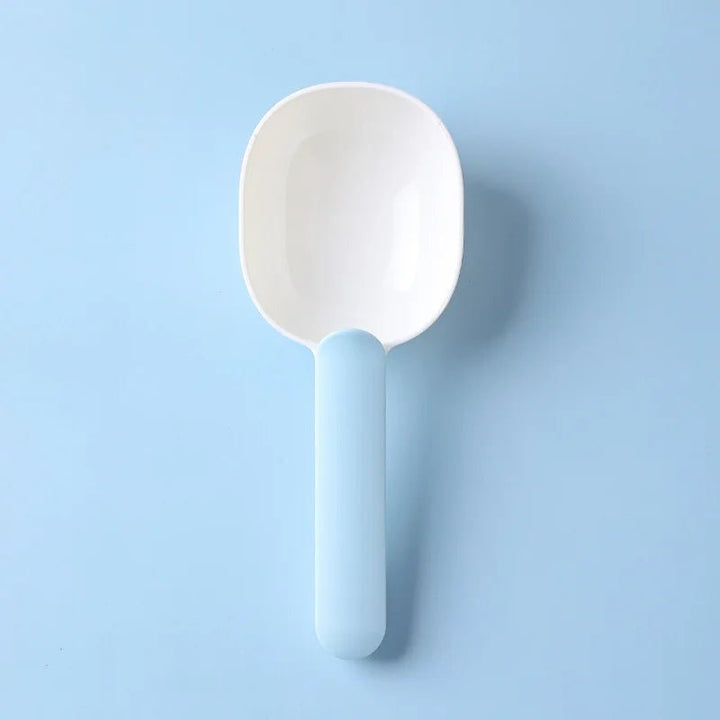 Blue and white pet food scoop shown on a blue background