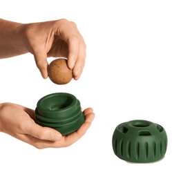 Hands placing a treat into a frozen treat toy for dogs