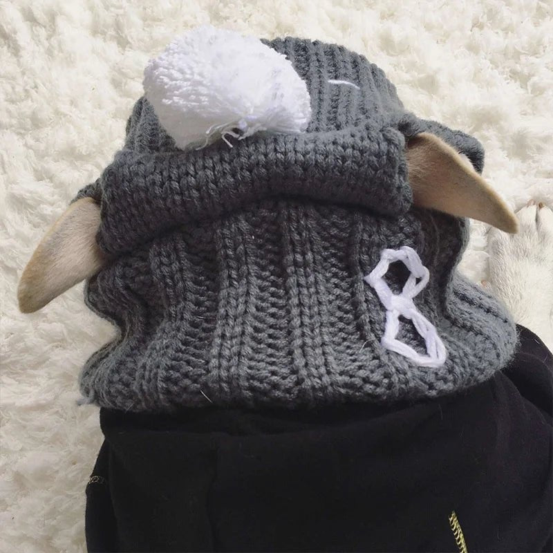 French Bulldog wearing a gray winter hat with ear holes and pom-pom, designed for warmth and comfort during cold days.