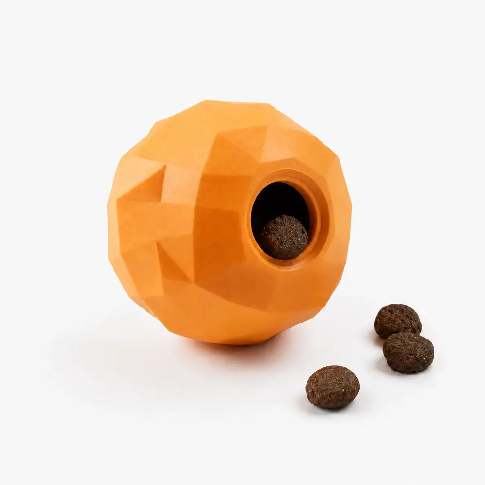 orange puppy hide treat toy with a central hole and three treats on a white background