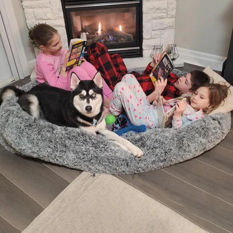 Large fluffy human dog bed with kids and a husky lounging by the fireplace, perfect for cozy moments with pets and family.