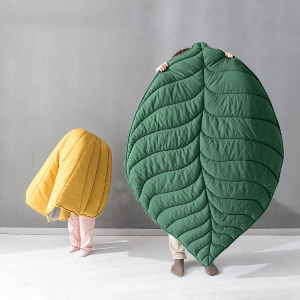 Leaf-shaped blankets in vibrant green and yellow, perfect as cozy mats or blankets for home decor and relaxation.