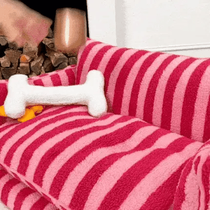 close up of a luxury dog bed sofa with striped fabric and a bone toy on the backrest
