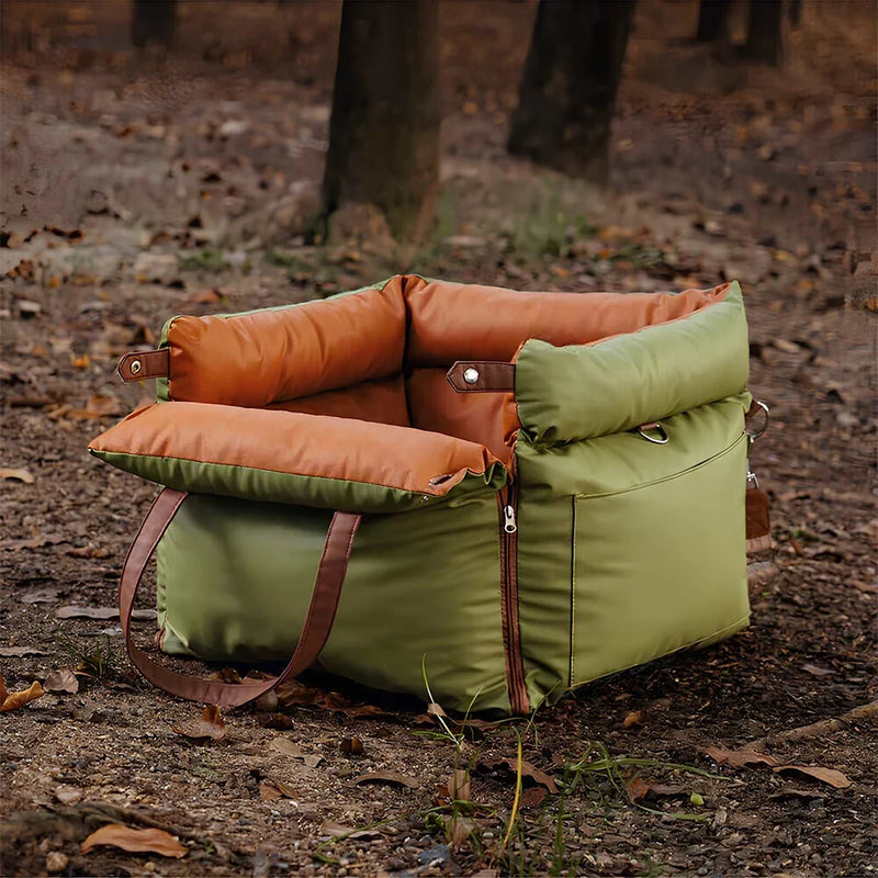 Luxury elevated dog car travel bed in orange and green placed outdoors with adjustable straps for secure fit.