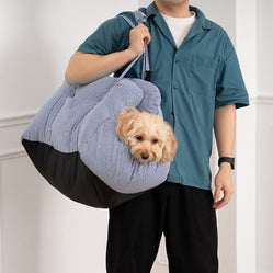 Man carrying car seat for pets with small dog inside
