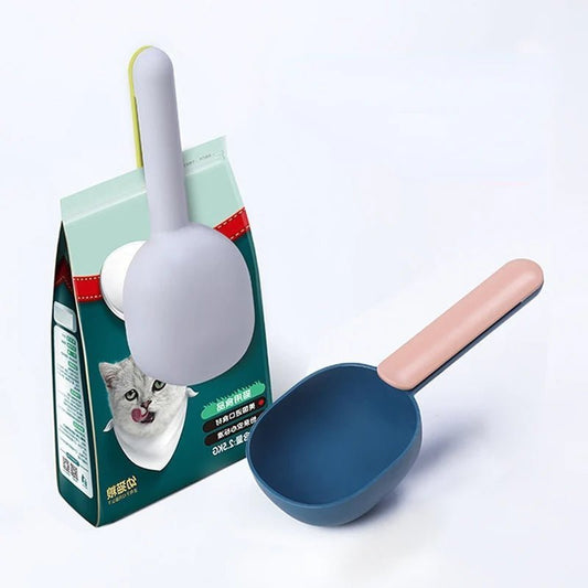 Blue and gray pet food scoop with magnetic handle, designed for easy attachment to food bags. Ideal for portion control.