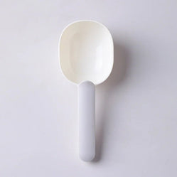 Minimalistic white pet food scoop with ergonomic handle, ideal for scooping pet food. Lightweight and easy to clean.