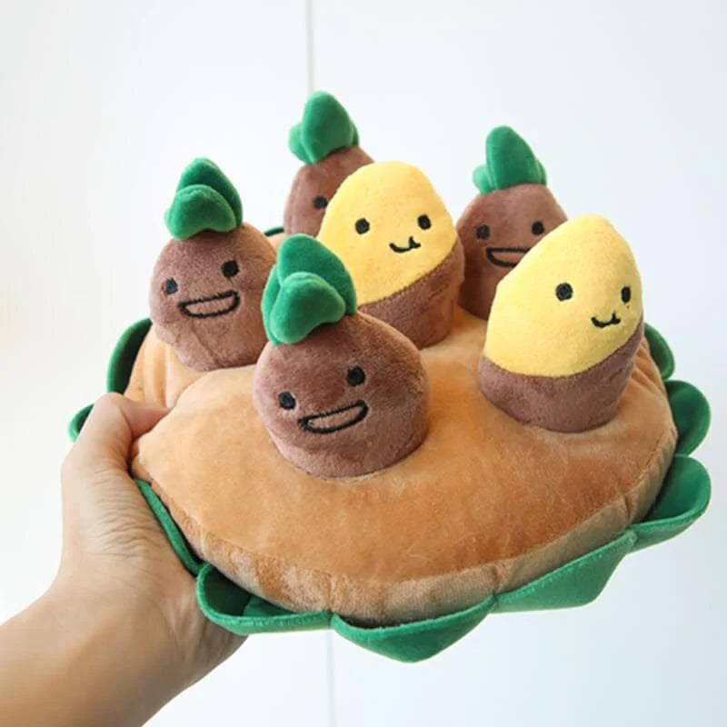 Hand holding plush potato dog sniffing toy with multiple interactive plush characters, stimulating puzzle toy for dogs