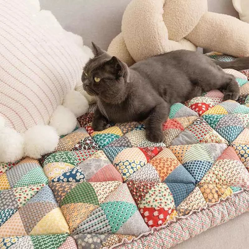 Cat relaxing on a colorful rainbow patchwork sofa cover, providing comfort and style for pet-friendly homes.