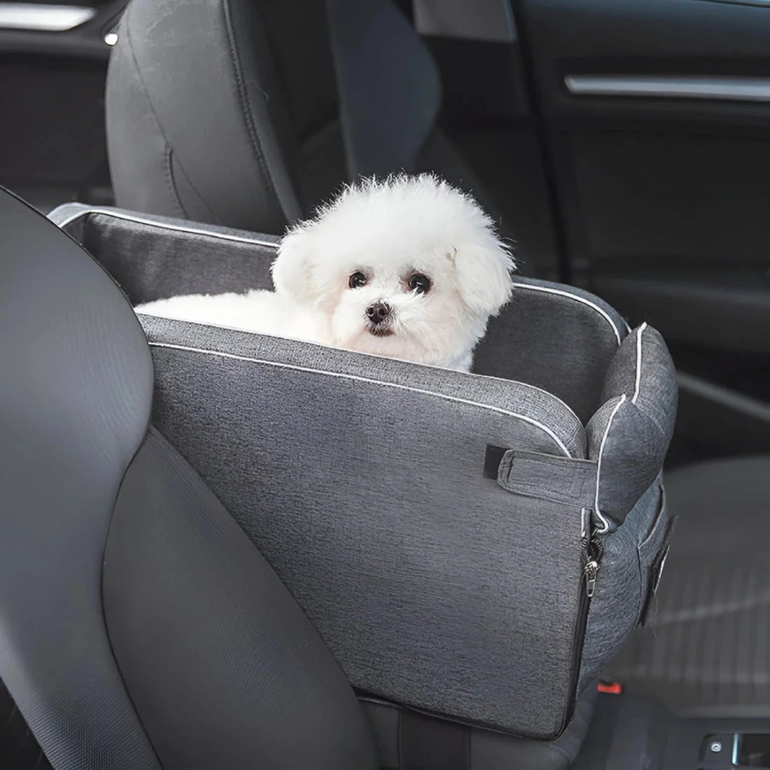 White fluffy dog sitting in a secure small pet travel car seat for comfortable and safe car journeys.