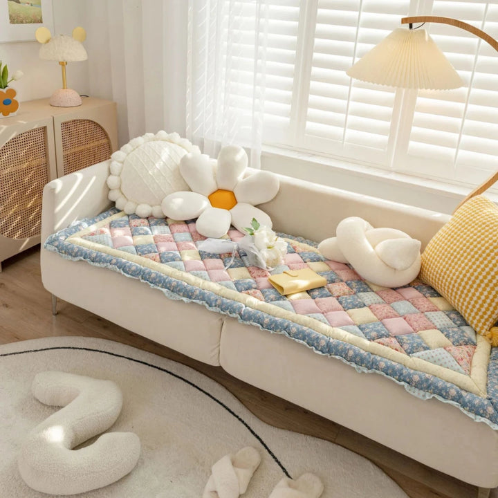 Blue pet sofa cover laid on couch with pillows and book