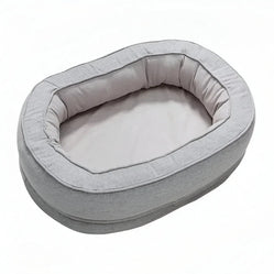 Soft oval donut dog bed in light gray, providing plush comfort and support for dogs, perfect for cozy lounging and sleeping.