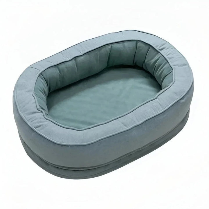 Soft oval donut dog bed in light green, providing cozy comfort and support for small to medium-sized dogs.