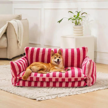 Dog lounging on a pink striped plush sofa bed for pets, providing soft and cozy comfort in a stylish home setting.