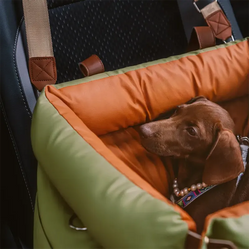 travel car bed for dogs attached to the car seat with a dog resting inside