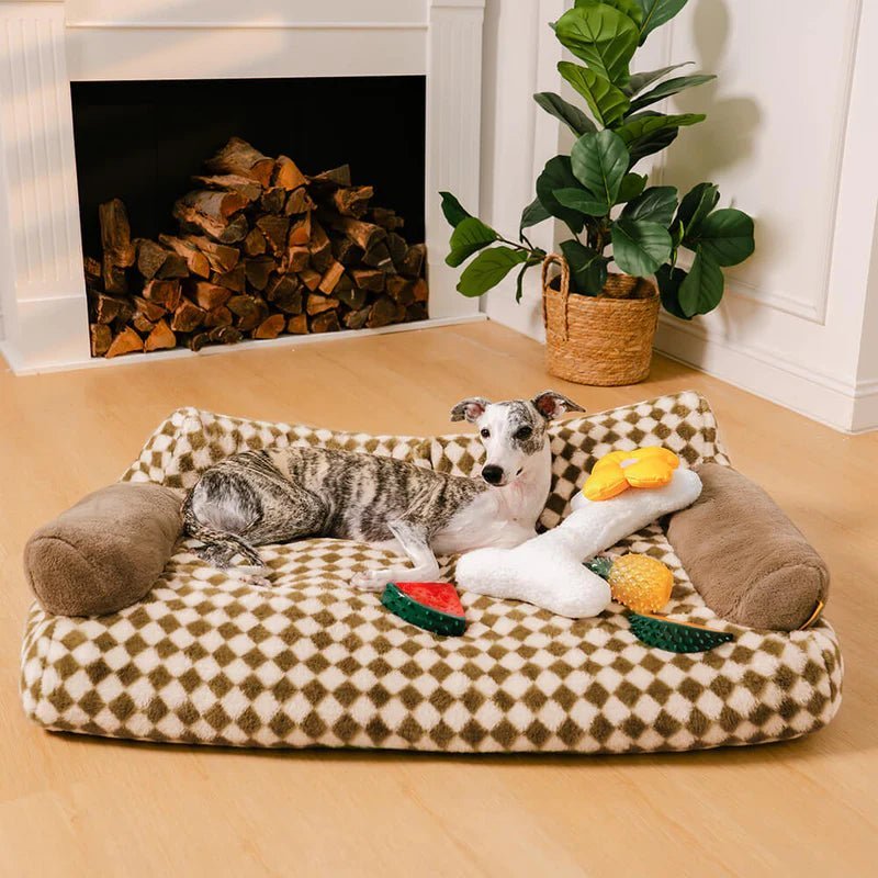 Whippet lounging on a cozy vintage-patterned pet sofa bed with plush toys, perfect for stylish pet relaxation.