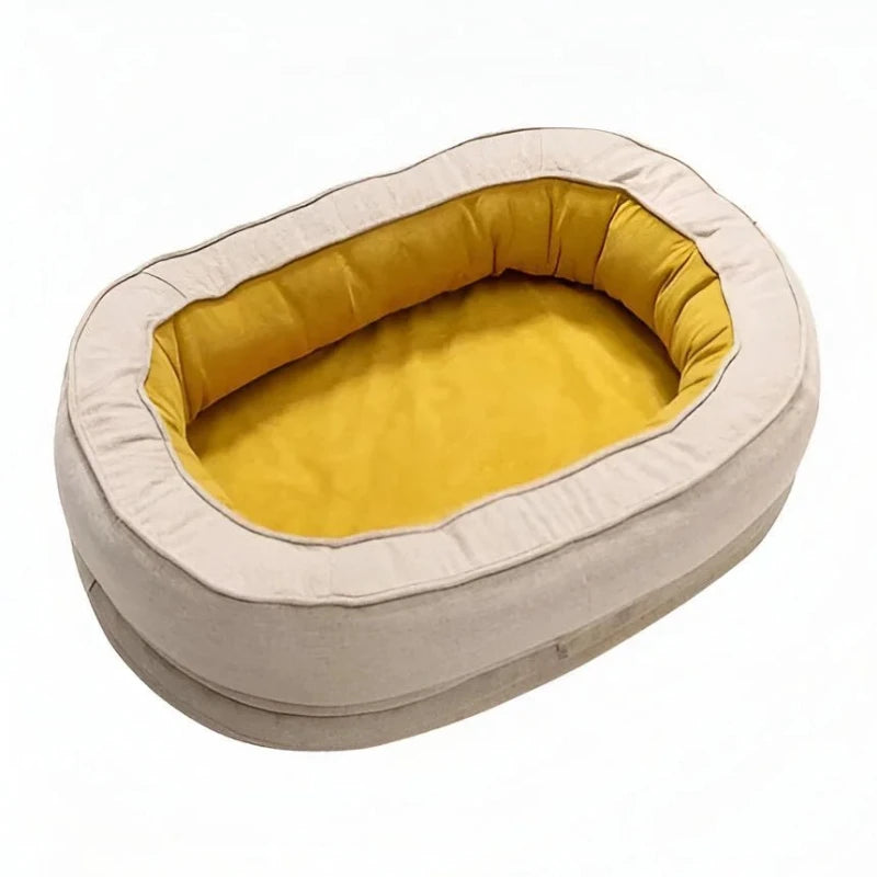 Yellow oval dog bed with padded bolster on white background